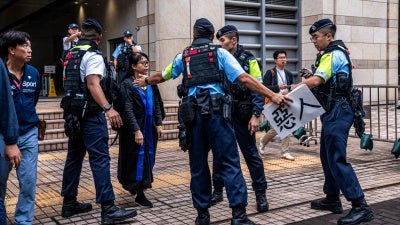 香港警察移除吕智恒养母Elsa Wu在西九龙裁判法院外抗议其子被国安法定罪的标语牌，香港